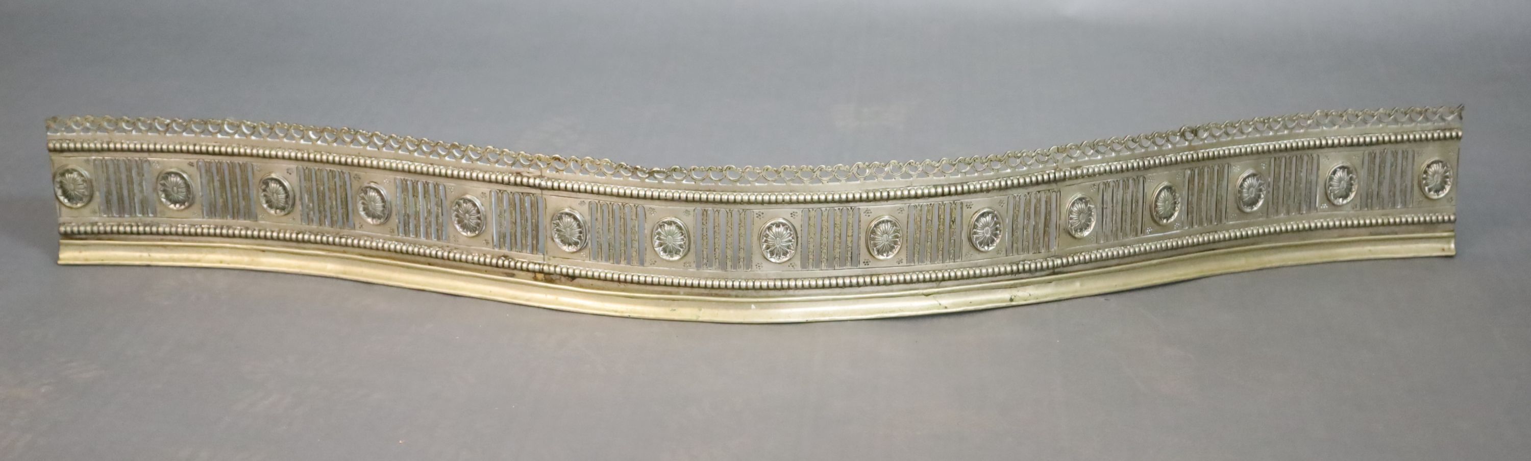 A George III bowed neo-classical fluted and pierced fender, W.145cm